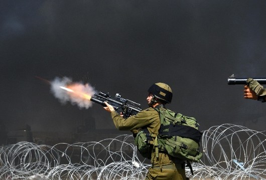 Izraelt vojci stlej slzn plyn na palestinsk demonstranty u checkpointu Kalandja nedaleko Ramallhu.